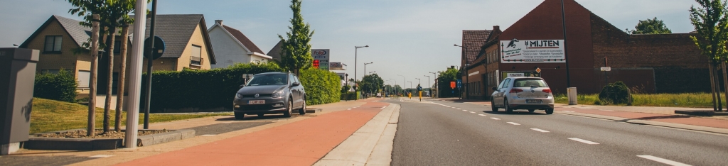 Foto van een weg met een fietspad ernaast.