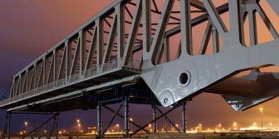 Foto van een kunstwerk (brug) bij avondlicht.